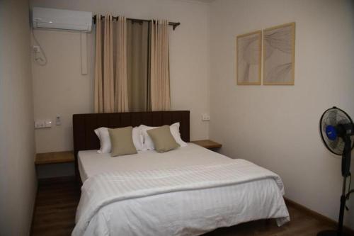 a bedroom with a large bed with white sheets and pillows at BnB Mahebourg apartment 2 in Mahébourg