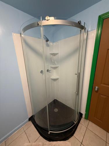 a glass shower in a corner of a room at OQP Hostel Miami in Miami