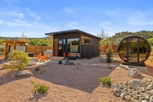 a small cabin with a large window in a yard at ABODE at East Zion in The Fields in Orderville