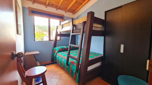 a bedroom with bunk beds with a table and a chair at Apartamento Acogedor en el Retiro in El Retiro