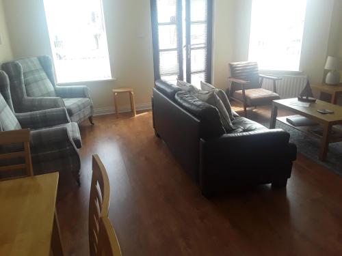 a living room with a couch and a chair at isleofmanholidayapartment in Douglas