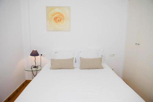 a bedroom with a white bed with two pillows at Mimoses Apartaments in Cadaqués