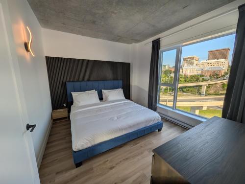 a bedroom with a bed and a large window at Suites Cobalt in Quebec City
