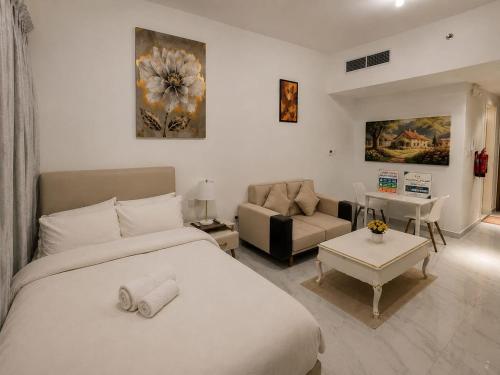a bedroom with a bed and a living room at شقة مصدر in Abu Dhabi