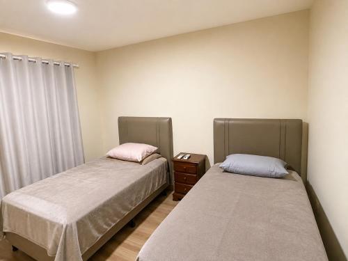two beds sitting next to each other in a room at Refúgio das Rosas in Pedro do Rio