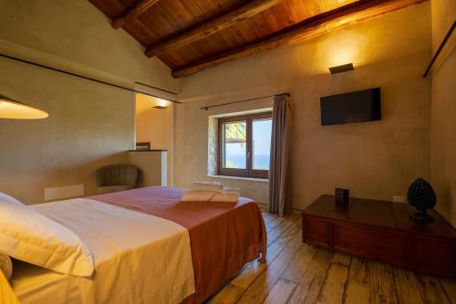 a bedroom with a large bed and a window at Mulino 1220 in Scopello