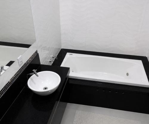 a bathroom with a sink and a bath tub at Paraíso Escarpas do Lago 1 - Capitólio in Capitólio