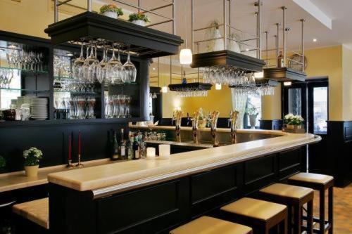 a bar in a restaurant with stools and glasses at Hotel Deitmer in Rhede