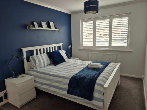 a bedroom with a white bed with blue walls at Seaside House Broadstairs by the Beach with Parking in Broadstairs