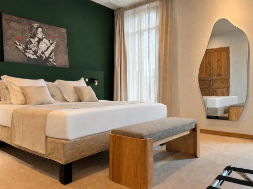 a bedroom with a large bed and a mirror at LE PALMIER Aigues-Mortes Petite Camargue in Aigues-Mortes