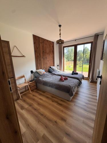 a bedroom with a bed and a large window at Przystanek Beztroska in Wydminy
