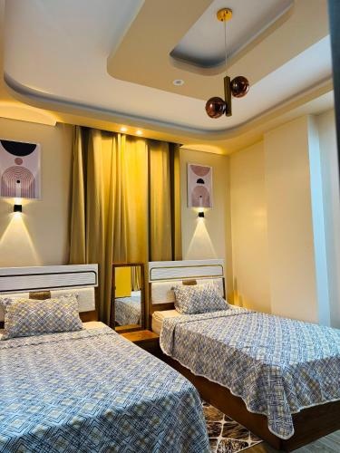 a hotel room with two beds and curtains at XOtel in Dumyāţ al Jadīdah