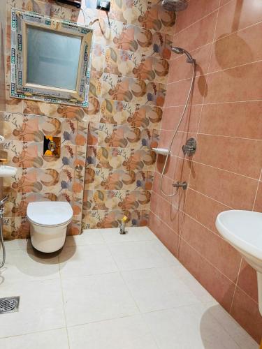 a bathroom with a toilet and a sink and a mirror at XOtel in Dumyāţ al Jadīdah