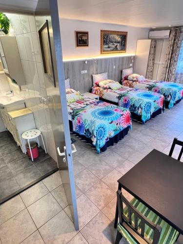 a room with two beds and a table in a room at Rooi Bij de Knoptoren B&B in Sint-Oedenrode