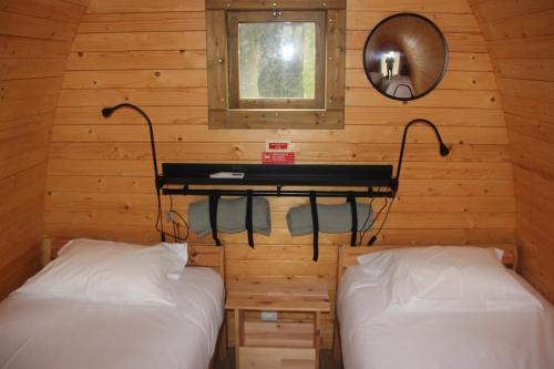 two beds in a room with a mirror and a table at Montejunto Bungalows in Cadaval