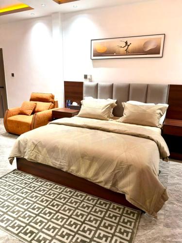 ein Schlafzimmer mit einem großen Bett und einem Stuhl in der Unterkunft Tijania Complex in Bijilo