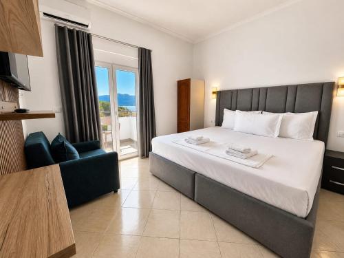 a hotel room with a large bed and a chair at Vila Bello in Ksamil