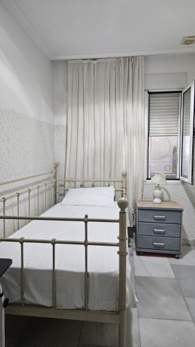 a bedroom with a bed and a dresser and a window at Habitacion en casa de familia "ValenciaBonita" in Valencia