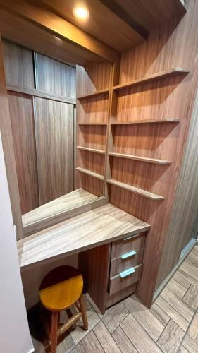a closet with wooden shelves and a wooden stool at Kings Boutique Hotel in Rio das Flores