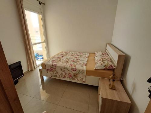 a small bed in a room with a window at Le Nid Côtier in Briech