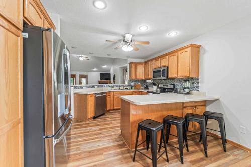 a kitchen with wooden cabinets and a refrigerator at Des Moines 4BR Family Getaway in Des Moines