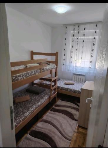 a room with two bunk beds and a rug at STAN NA DAN Stara Pazova in Stara Pazova