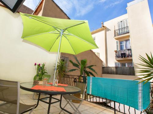 - une table avec un parasol vert sur le balcon dans l'établissement Studios Alea, à Cannes