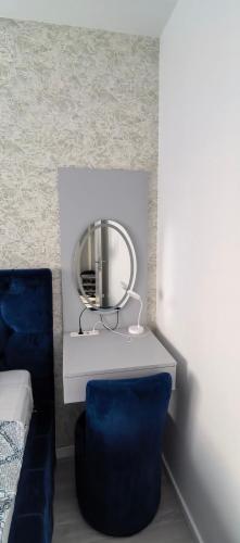 a dressing table with a mirror and a blue chair at Apartman Vaske 2 sa GARAŽOM in Brčko