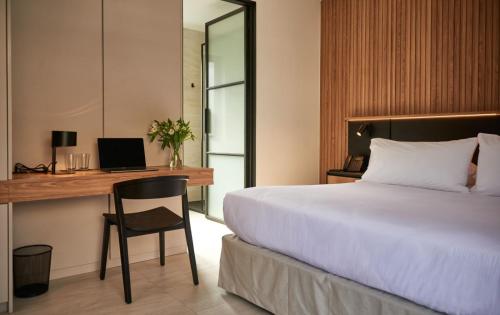a bedroom with a bed and a desk with a computer at Lastarria Hotel in Santiago