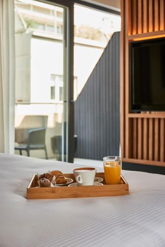 a tray with breakfast foods and a glass of orange juice at Lastarria Hotel in Santiago