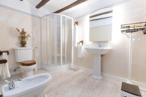 a white bathroom with a toilet and a sink at Casa rural Casa Leles in Lagata