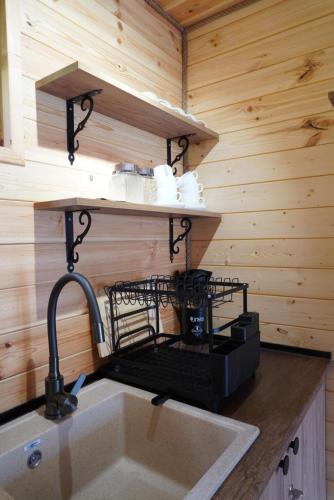 a kitchen with a sink in a log cabin at Elia Hut Kazbegi in Kazbegi