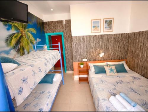 a bedroom with two beds and a tv on the wall at Guesthouse Tossa de Mar in Tossa de Mar