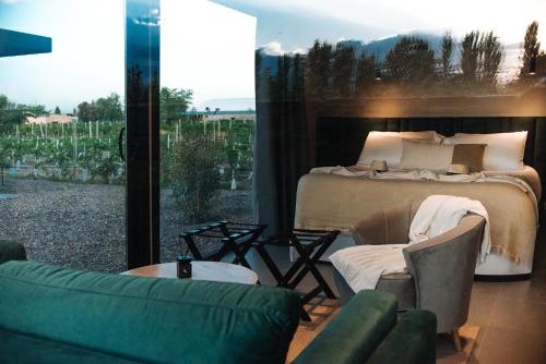 a bedroom with a bed and a large window at Legado Wine Lodge in Maipú