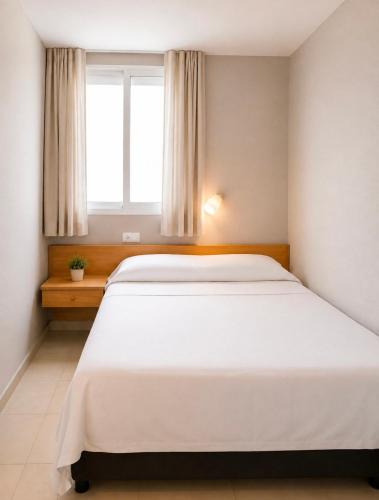a large white bed in a room with a window at Guesthouse Tossa de Mar in Tossa de Mar
