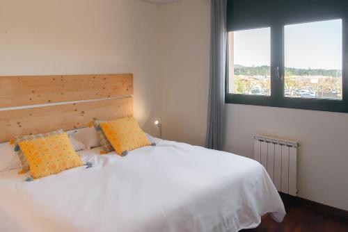 a bedroom with a white bed with two orange pillows at WELCS CASA 423 PDA con piscina in Vall-Llobrega