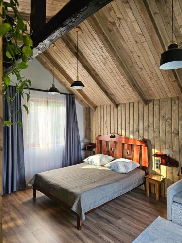 a bedroom with a bed in a room with wooden walls at Садиба "333" in Yaremche