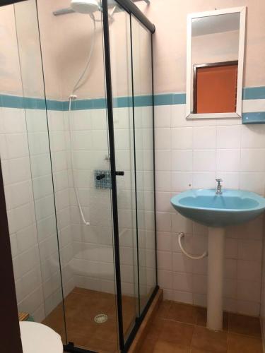a bathroom with a glass shower and a sink at Aconchego Mineiro in Visconde De Maua