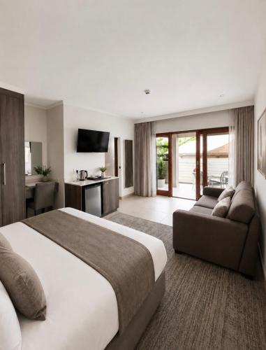 a bedroom with a large bed and a couch at BoniM Guesthouse - aka Magisha Guesthouse in Nelspruit