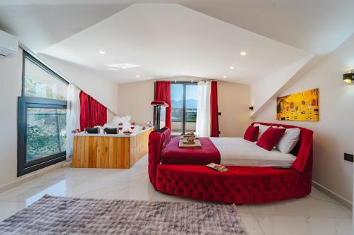 a bedroom with a red bed and a red chair at Villa Bella in Doger Koyu