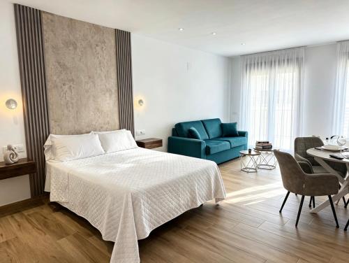 a bedroom with a bed and a blue couch at La Serrería-Premium Suite Apartments & Private Jacuzzi in Belmonte