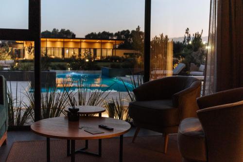 a living room with a table and chairs and a pool at Legado Wine Lodge in Maipú