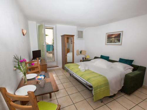 Un dormitorio con una cama y una mesa y sillas. en Studios Alea, en Cannes