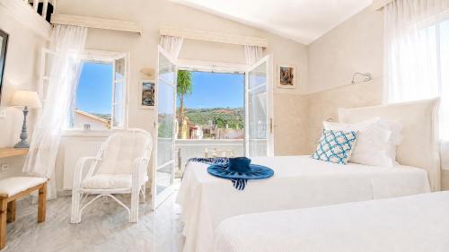 a bedroom with two beds and a window at Villa Kallergi Athena in Loutra