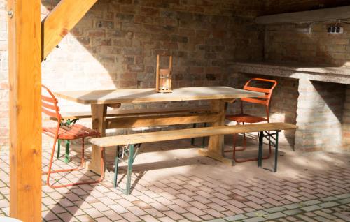 a wooden table with two chairs and a bench at Tompos Vendégház és pince in Villány