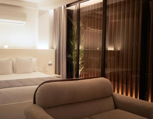 a bedroom with a bed and a couch and a window at Casa Patrones in Chiclayo