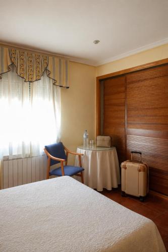 a room with a bed and a table and a window at Hostal Guadiana in Ruidera