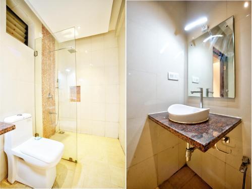 a bathroom with a toilet and a sink and a shower at Ocean n' Sand - By Q23 Resorts & Suites in Candolim
