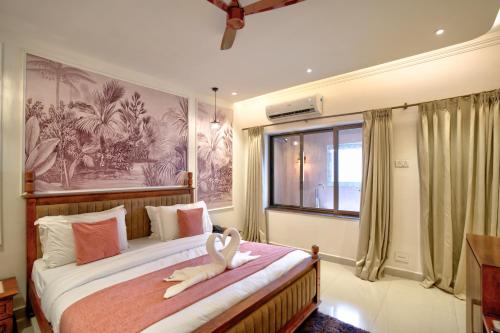a bedroom with two beds with a swan on them at Ocean n' Sand - By Q23 Resorts & Suites in Candolim