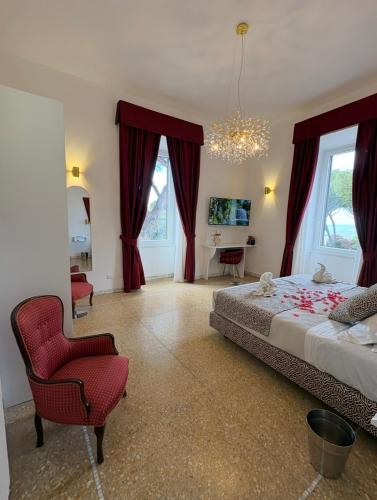 a bedroom with a large bed and a red chair at Maison 900 in Tivoli